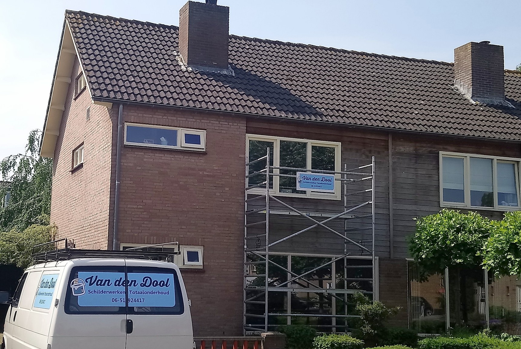 Steiger met het bord van Van den Dool voor een woning, de witte bedrijfsbus ervoor